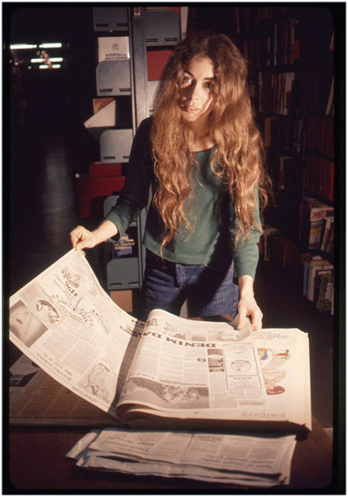 Annastacia McDonald looks through newspapers at the Vancouver Public Library, 1976, Courtesy of Paul Wong